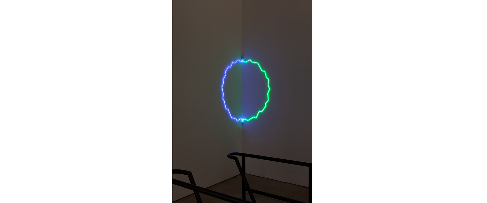 “Edged Circle in Corner” – 2019, transparentes blaues und grünes Glas, Argon, Transformator, Durchmesser 150 cm